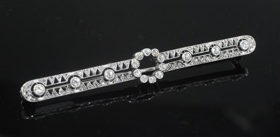 A 1920s white gold and diamond set pierced openwork bar brooch, 68mm.